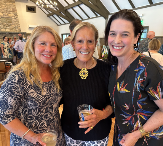 Three women enjoying at a cocktail party.